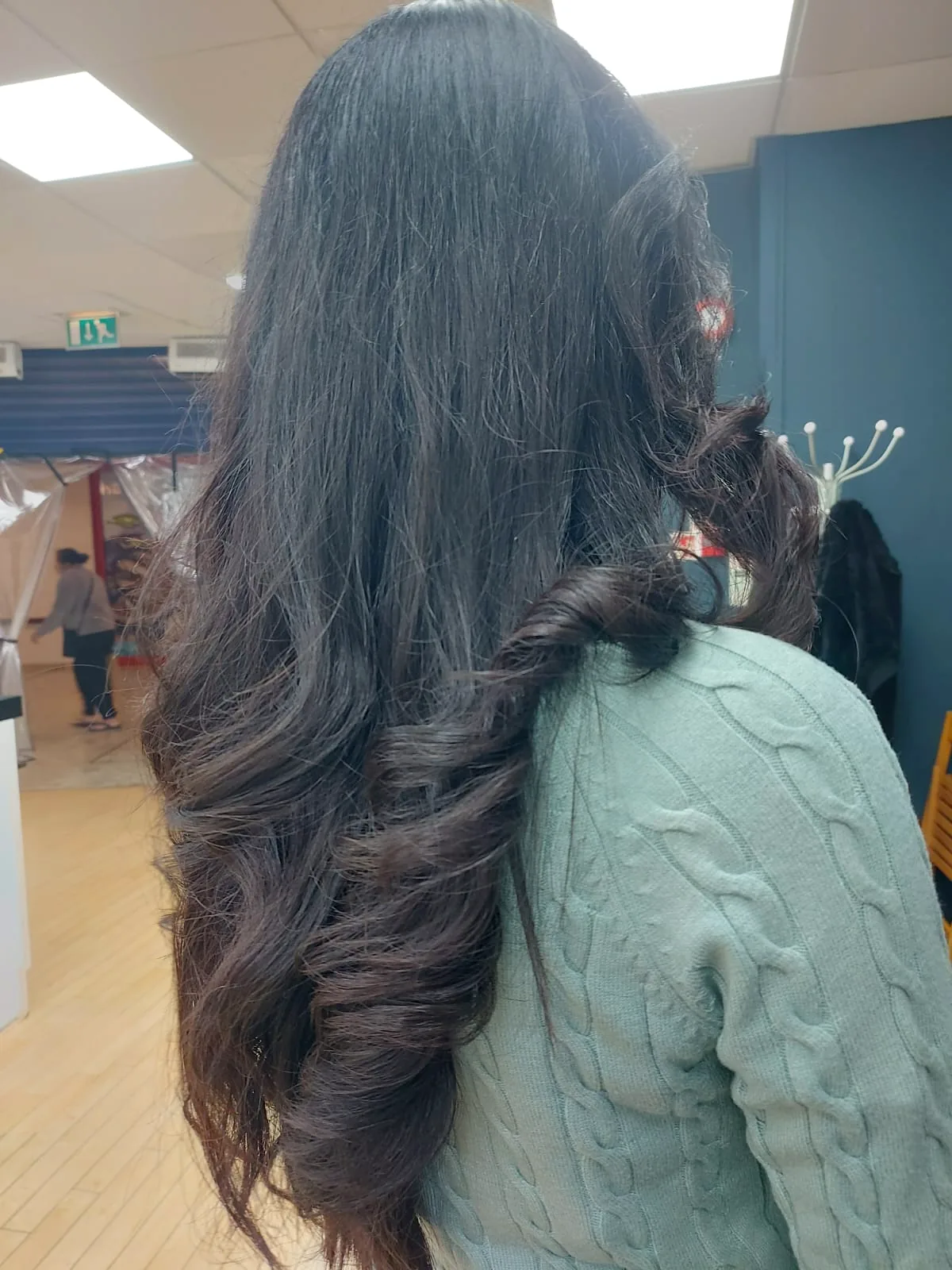 Long dark hair styled into voluminous glossy waves by MARSELINE mobile hair stylist